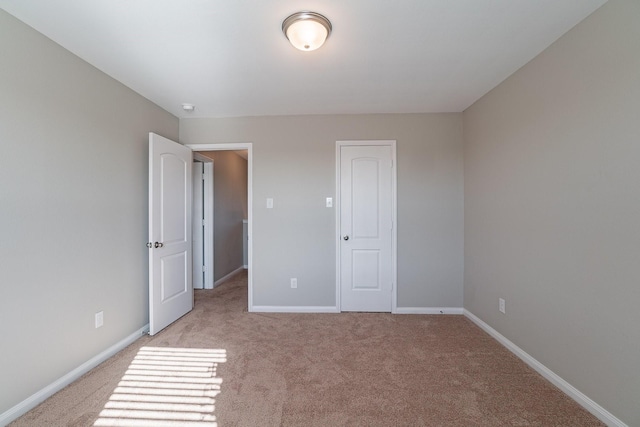 unfurnished bedroom featuring light carpet and a closet