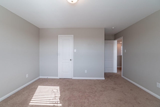 unfurnished bedroom featuring light carpet and a closet