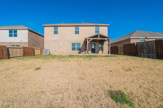 back of property featuring a lawn, central air condition unit, and a patio