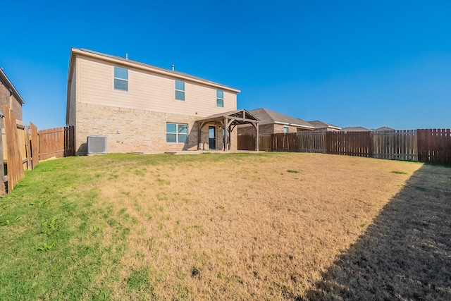 back of property with central AC unit and a lawn