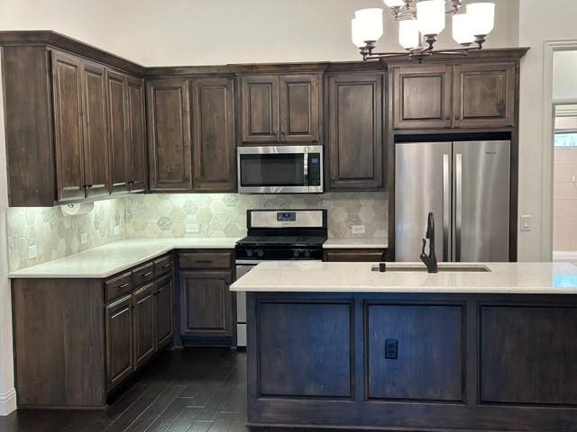 kitchen featuring stainless steel appliances, a chandelier, and dark brown cabinetry