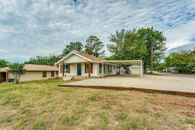 view of front of property featuring a carport, a garage, an outdoor structure, a front yard, and covered porch