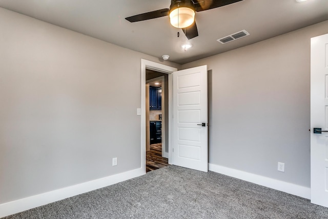 empty room featuring dark colored carpet and ceiling fan