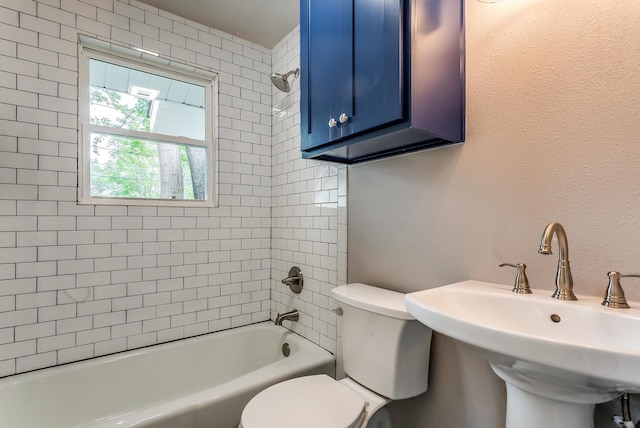 full bathroom with toilet, tiled shower / bath, and sink