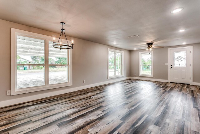 interior space with hardwood / wood-style floors, ceiling fan with notable chandelier, and a healthy amount of sunlight