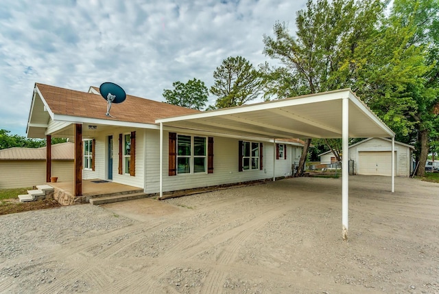 view of front of house with a garage, an outdoor structure, a porch, and a carport