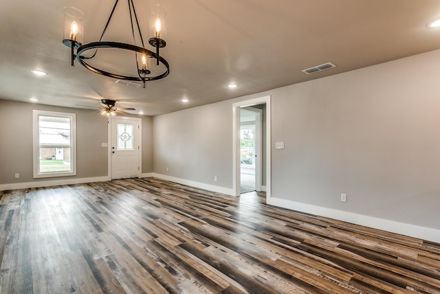 spare room featuring hardwood / wood-style floors and ceiling fan with notable chandelier