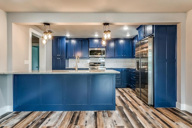 kitchen with blue cabinetry, pendant lighting, light wood-type flooring, and appliances with stainless steel finishes