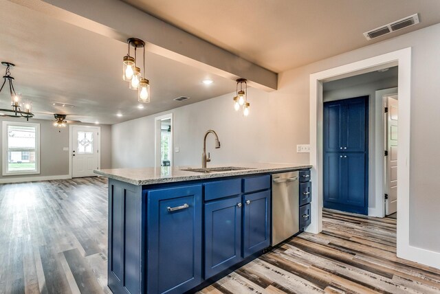 kitchen featuring pendant lighting, dishwasher, a center island with sink, blue cabinets, and sink