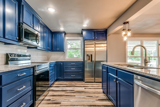 kitchen with light hardwood / wood-style floors, sink, blue cabinets, and stainless steel appliances