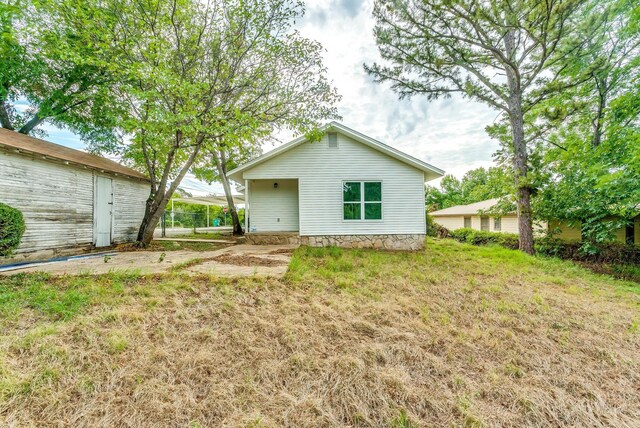 rear view of house featuring a yard