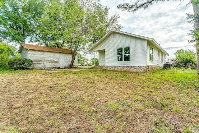 back of house featuring a storage shed and a yard