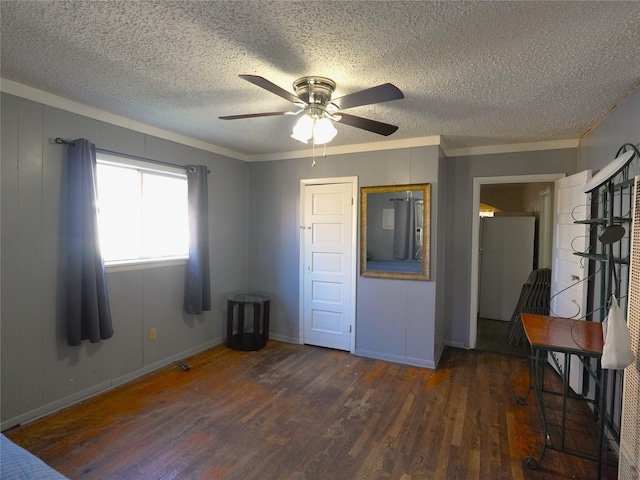 unfurnished bedroom featuring ceiling fan, dark hardwood / wood-style flooring, crown molding, and a textured ceiling