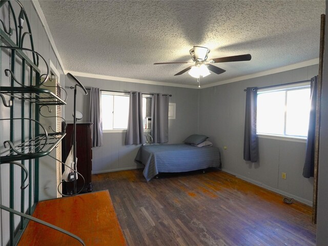 unfurnished bedroom with dark hardwood / wood-style flooring, multiple windows, crown molding, and ceiling fan