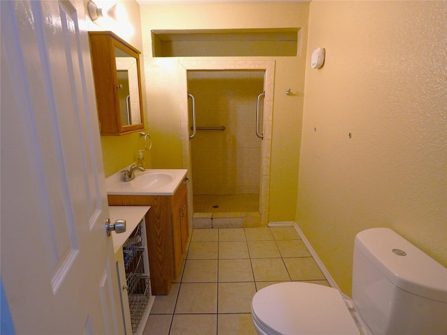 bathroom with tile patterned floors, vanity, a tile shower, and toilet