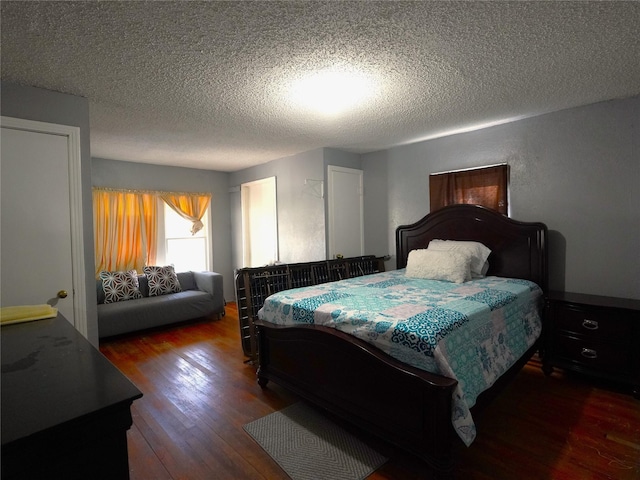 bedroom with dark hardwood / wood-style flooring and a textured ceiling