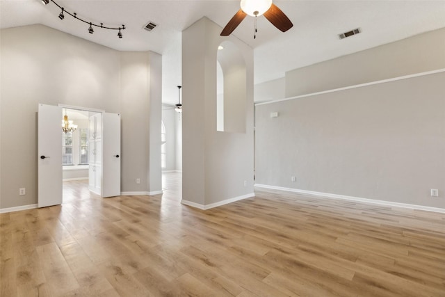 interior space with high vaulted ceiling, light hardwood / wood-style floors, and ceiling fan with notable chandelier