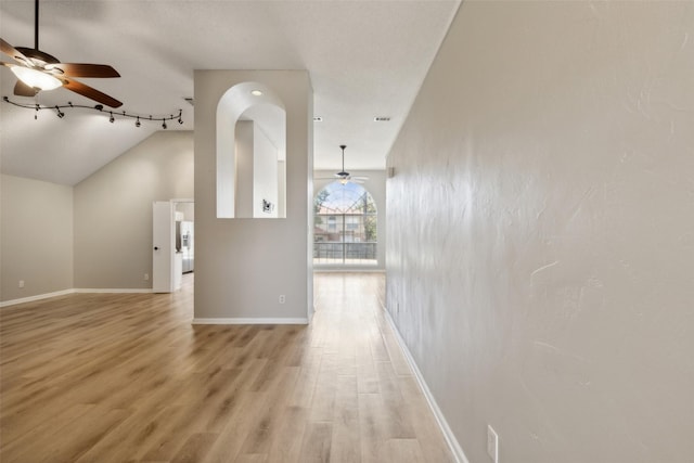 interior space featuring light wood-type flooring, vaulted ceiling, and ceiling fan