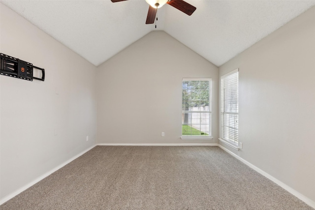 carpeted empty room with ceiling fan and vaulted ceiling