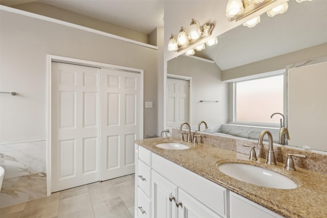 bathroom featuring tile patterned floors, vanity, and vaulted ceiling