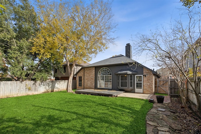 rear view of property with a deck and a lawn