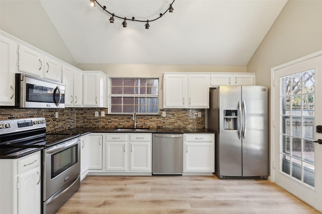 kitchen with white cabinets, appliances with stainless steel finishes, light wood-type flooring, and sink