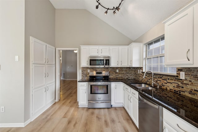 kitchen with tasteful backsplash, sink, white cabinets, and appliances with stainless steel finishes