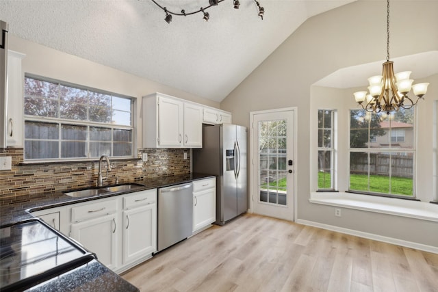 kitchen with pendant lighting, white cabinetry, sink, and appliances with stainless steel finishes