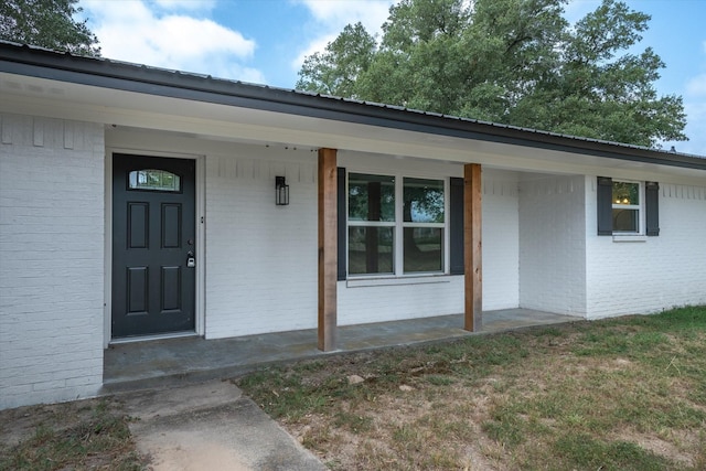 view of exterior entry featuring covered porch