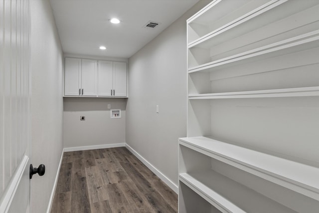 laundry area featuring dark hardwood / wood-style flooring, cabinets, hookup for a washing machine, and hookup for an electric dryer