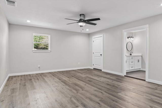 unfurnished bedroom with connected bathroom, light hardwood / wood-style flooring, and ceiling fan