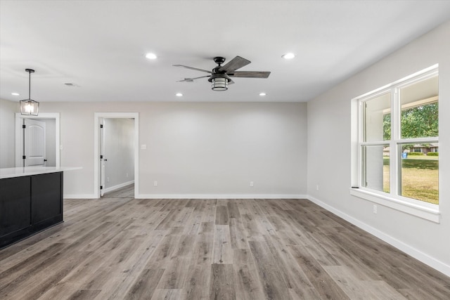 unfurnished living room with ceiling fan and light wood-type flooring