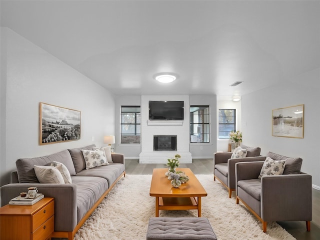 living room with light hardwood / wood-style flooring and a brick fireplace