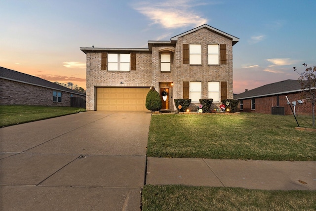 traditional-style house with an attached garage, driveway, brick siding, and a front yard