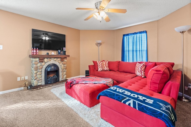 carpeted living area with a ceiling fan, a fireplace, a textured ceiling, and baseboards