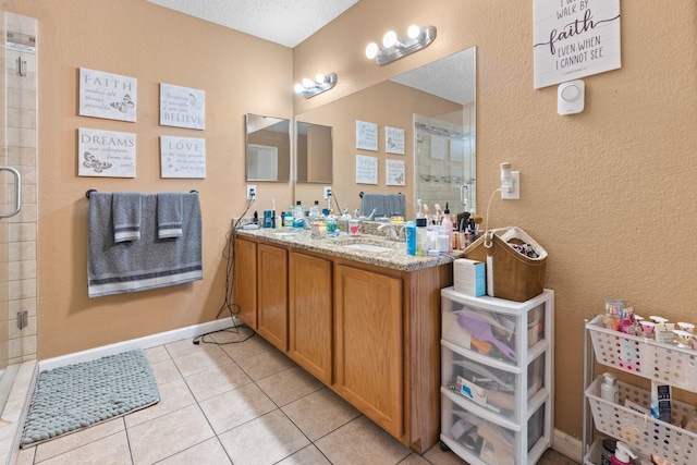 bathroom featuring a sink, baseboards, a shower stall, tile patterned floors, and double vanity