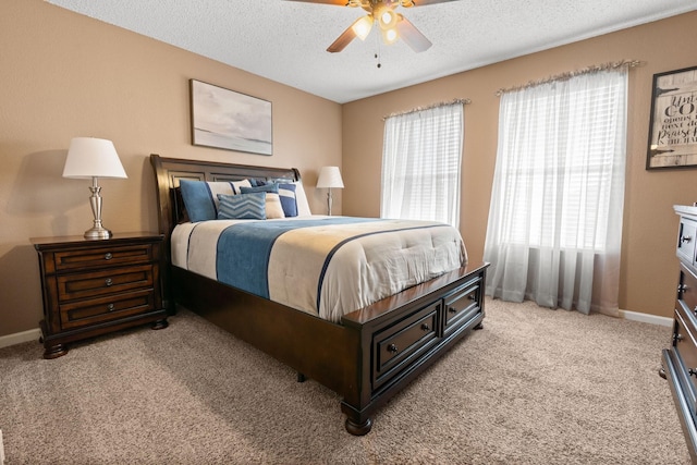 bedroom with a ceiling fan, light carpet, a textured ceiling, and baseboards