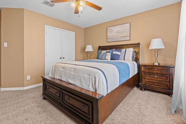 carpeted bedroom featuring a ceiling fan, a closet, visible vents, and baseboards