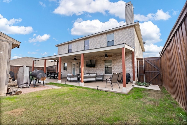 back of house featuring brick siding, a yard, an outdoor hangout area, a gate, and fence