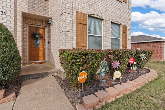 doorway to property featuring brick siding