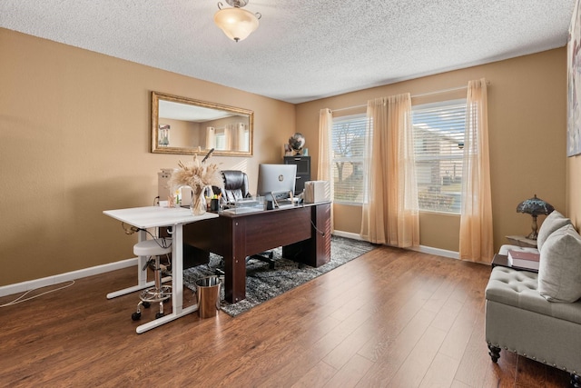 office area with a textured ceiling, wood finished floors, and baseboards