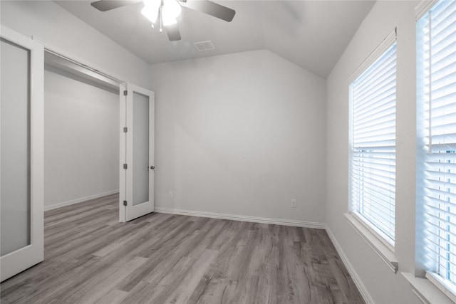 unfurnished bedroom featuring ceiling fan, vaulted ceiling, a closet, and light hardwood / wood-style flooring