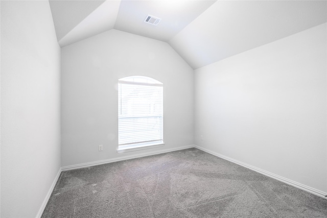 empty room with carpet floors and vaulted ceiling