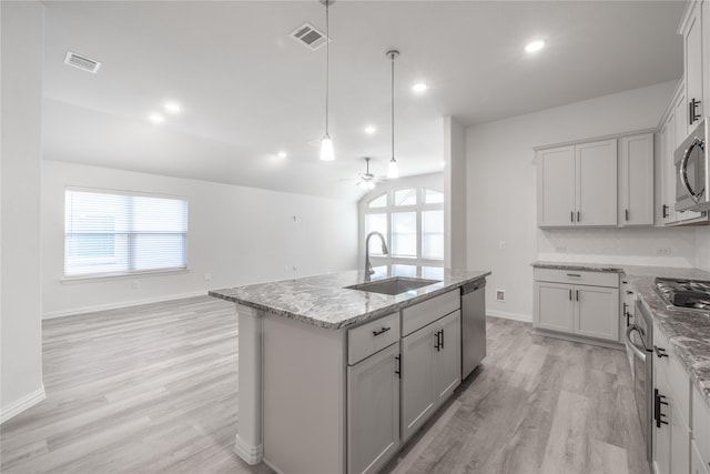 kitchen with ceiling fan, sink, an island with sink, light hardwood / wood-style floors, and appliances with stainless steel finishes