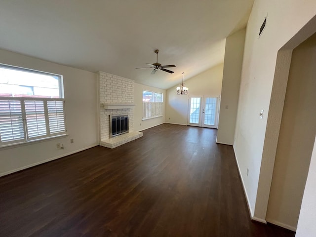 unfurnished living room featuring ceiling fan, french doors, a brick fireplace, dark hardwood / wood-style flooring, and vaulted ceiling