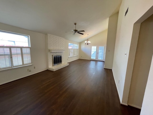 unfurnished living room with a brick fireplace, dark hardwood / wood-style flooring, vaulted ceiling, and plenty of natural light