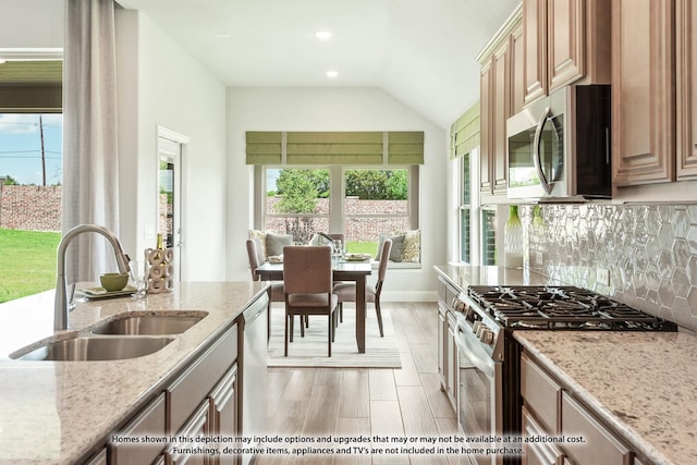 kitchen featuring decorative backsplash, appliances with stainless steel finishes, a healthy amount of sunlight, and sink