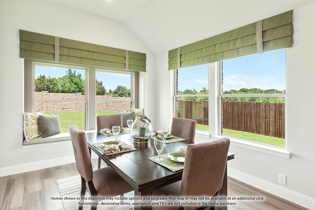 dining space with light hardwood / wood-style flooring and vaulted ceiling