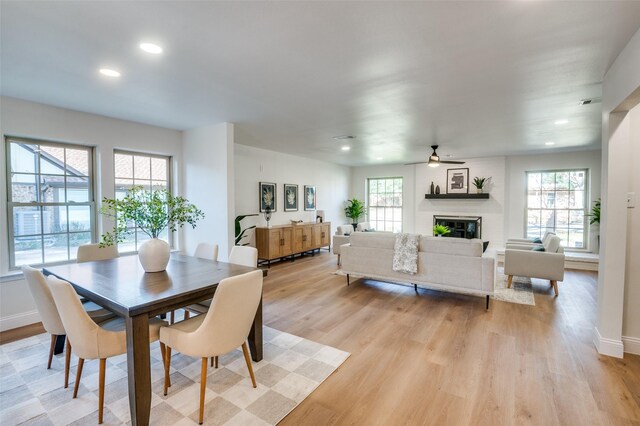 kitchen with sink, hanging light fixtures, a center island, a kitchen bar, and light wood-type flooring