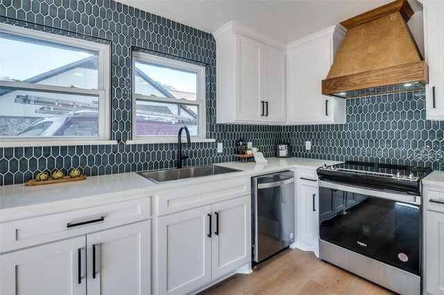 kitchen featuring white cabinetry, hanging light fixtures, stainless steel appliances, a kitchen island, and custom exhaust hood